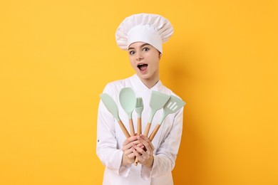 Professional chef with kitchen utensils on yellow background