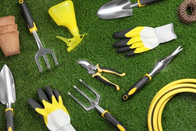 Flat lay composition with gardening tools on green grass