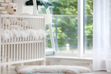 Photo of Baby room interior with crib near window