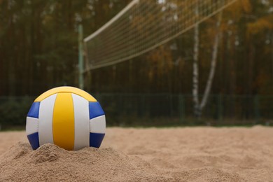 Photo of Colorful volleyball ball on sand court, space for text
