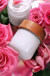 Photo of Jars of face cream among beautiful roses