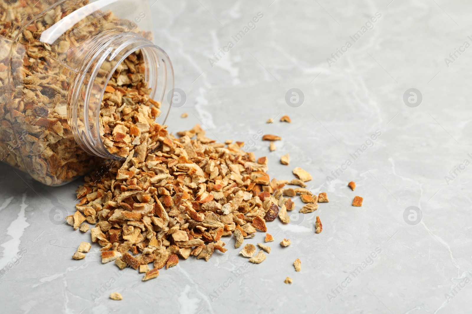 Photo of Jar with dried orange zest seasoning on light grey table, closeup. Space for text