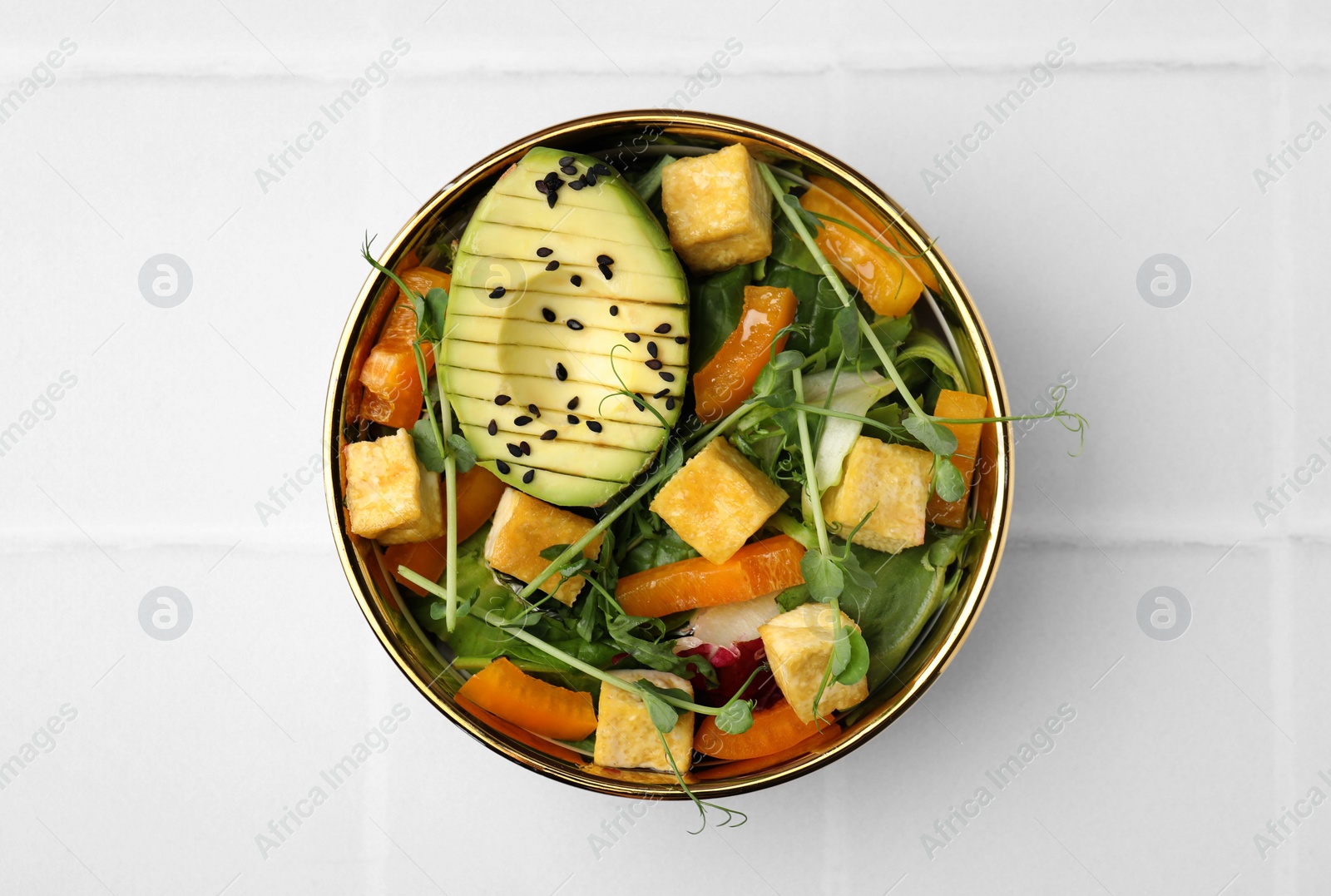 Photo of Delicious salad with tofu and vegetables on white tiled table, top view