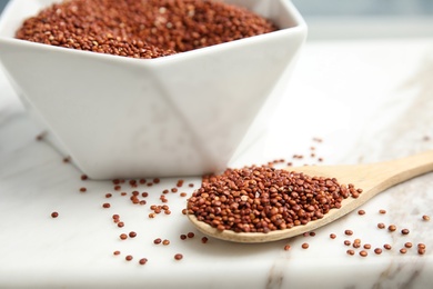 Photo of Bowl and spoon with red quinoa on marble board