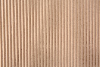 Texture of beige corrugated paper sheet as background, closeup