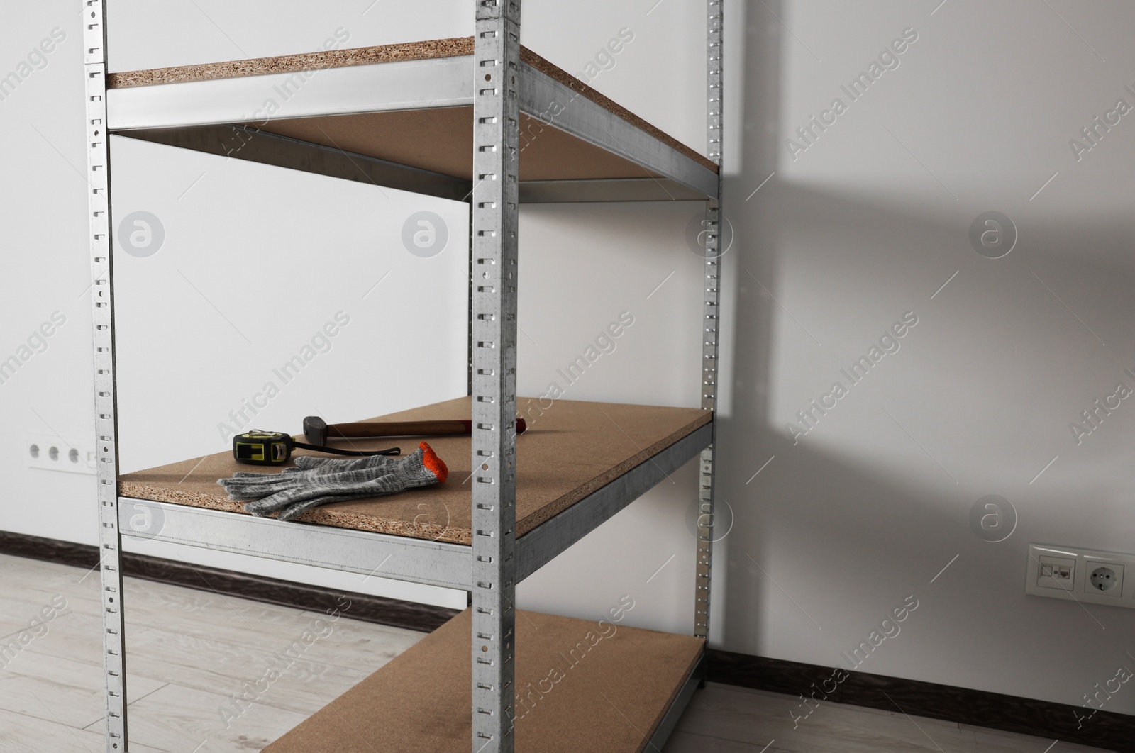 Photo of Metal storage shelf with room renovation tools in office