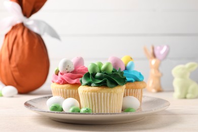 Photo of Tasty cupcakes with Easter decor on wooden table