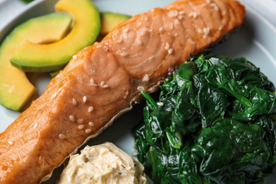 Photo of Tasty salmon with spinach and avocado, closeup