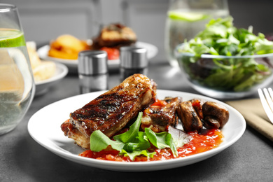 Delicious grilled ribs served on grey table