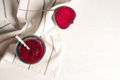 Photo of Glass of beet smoothie on white wooden background with space for text, top view