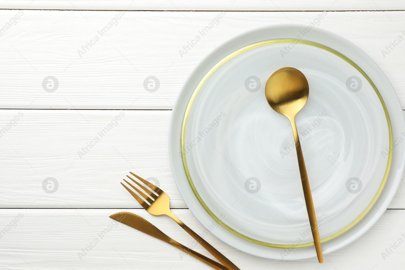 Photo of Stylish setting with cutlery and plate on white wooden table, flat lay. Space for text