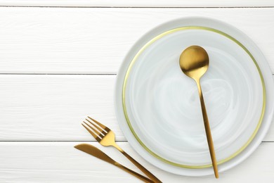 Photo of Stylish setting with cutlery and plate on white wooden table, flat lay. Space for text