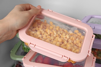 Woman taking box with corn kernels from refrigerator, closeup