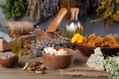 Photo of Many different dry herbs on wooden table