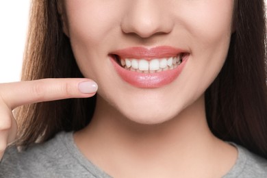 Woman showing healthy gums on white background, closeup