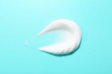 Photo of Sample of face cream on light blue background, top view