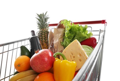 Shopping cart with groceries on white background, closeup