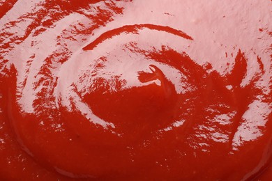 Photo of Tasty ketchup as background, closeup. Tomato sauce