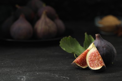 Tasty raw figs on black slate table. Space for text