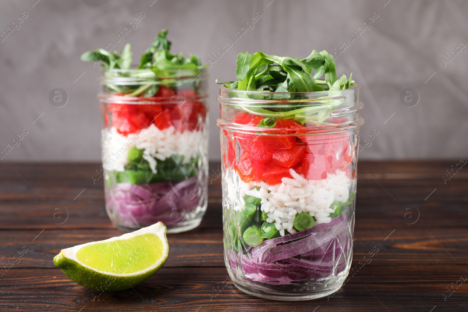 Photo of Healthy salad in glass jars on wooden table