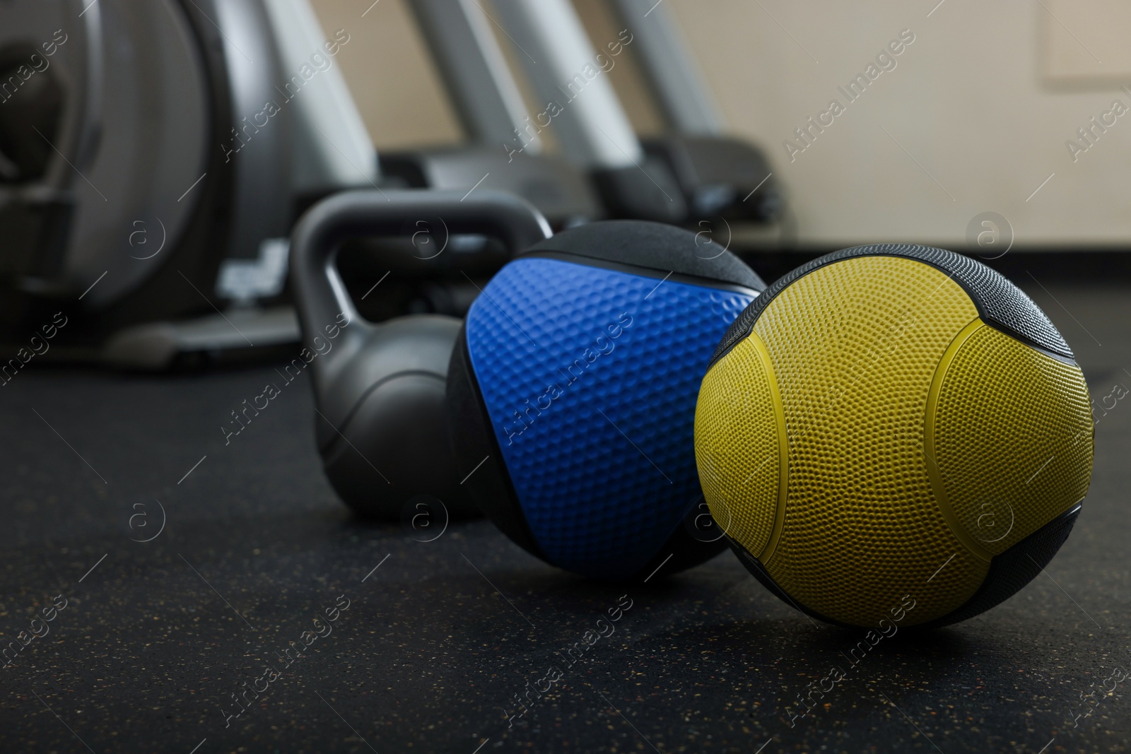Photo of Medicine balls and kettlebell on floor in gym