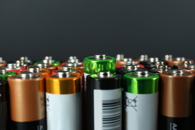 Image of Many AA batteries on grey background, closeup. Space for text