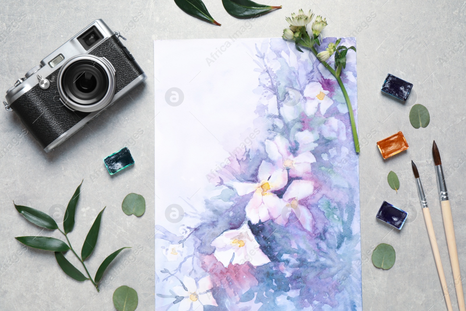 Photo of Flat lay composition with watercolor paints and floral picture on grey stone table