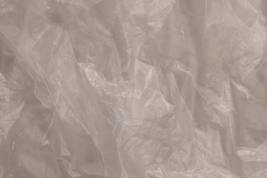 Photo of Crumpled yellow plastic bag as background, top view