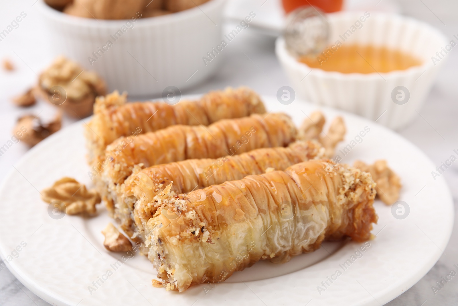 Photo of Eastern sweets. Pieces of tasty baklava on white table, closeup