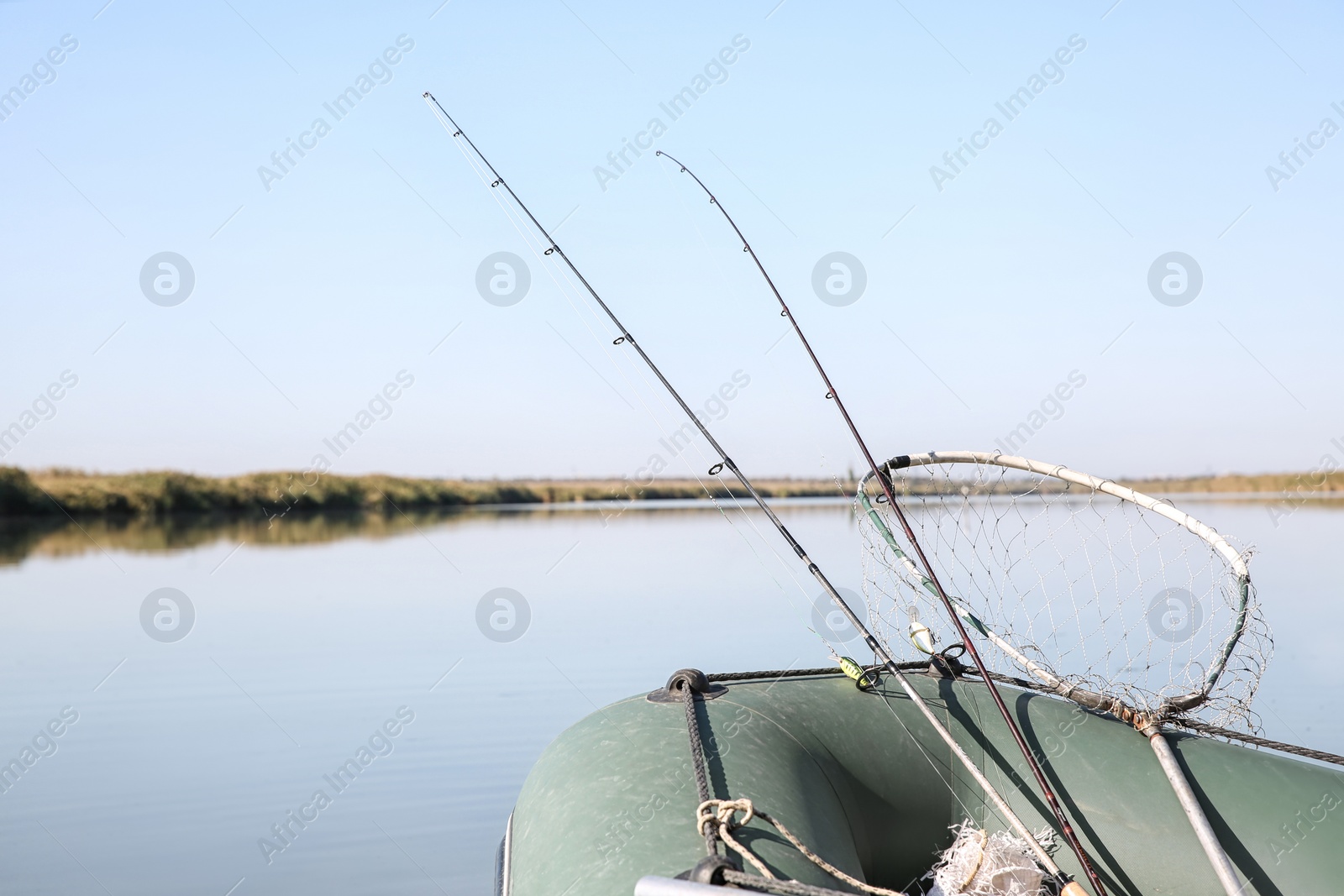 Photo of Fishing rods in inflatable boat on river