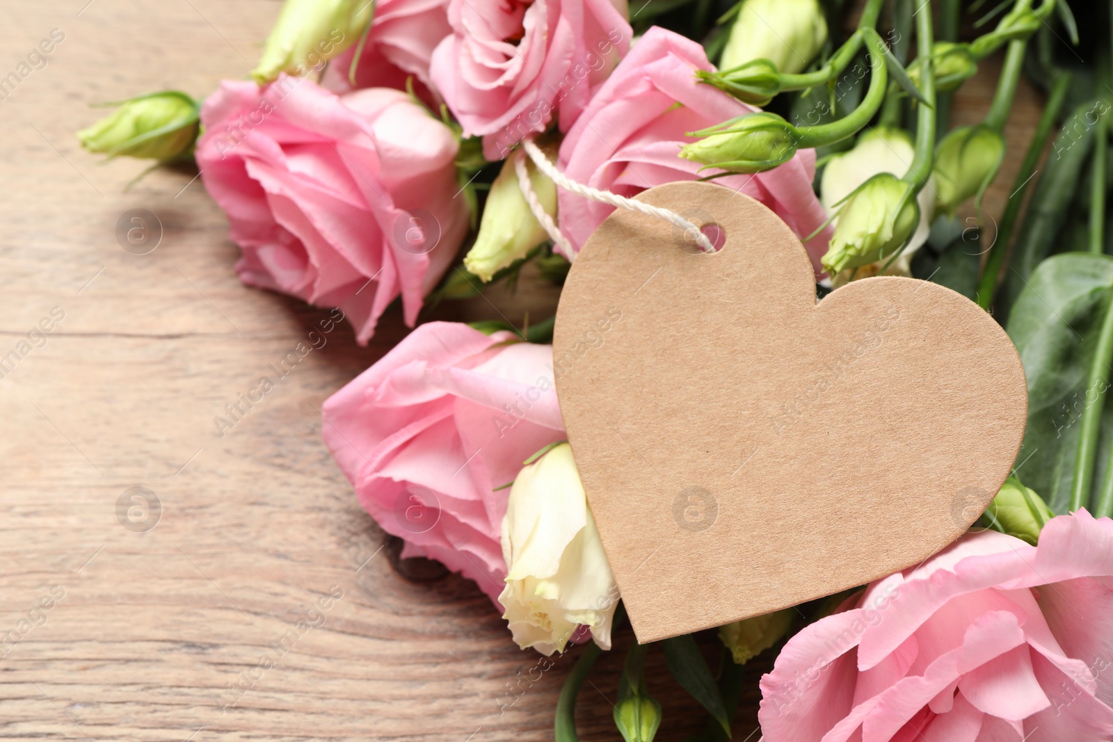 Photo of Happy Mother's Day. Beautiful flowers and blank heart shaped card on wooden table, closeup. Space for text