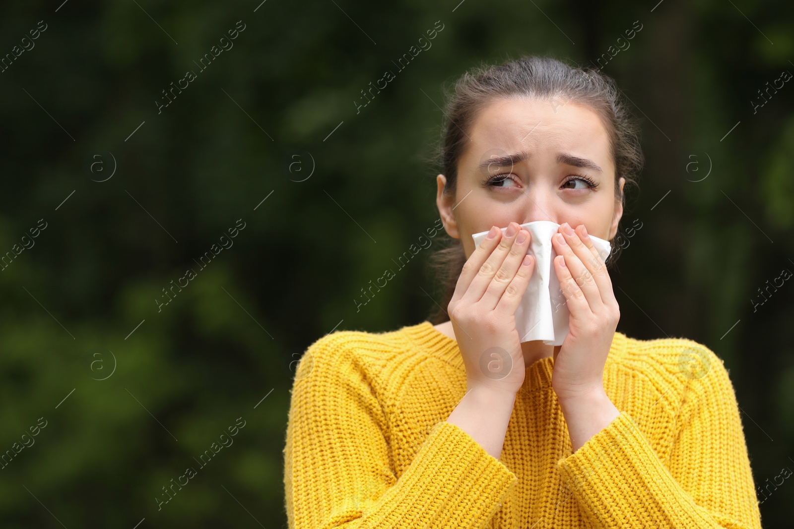 Photo of Woman suffering from seasonal spring allergy outdoors, space for text