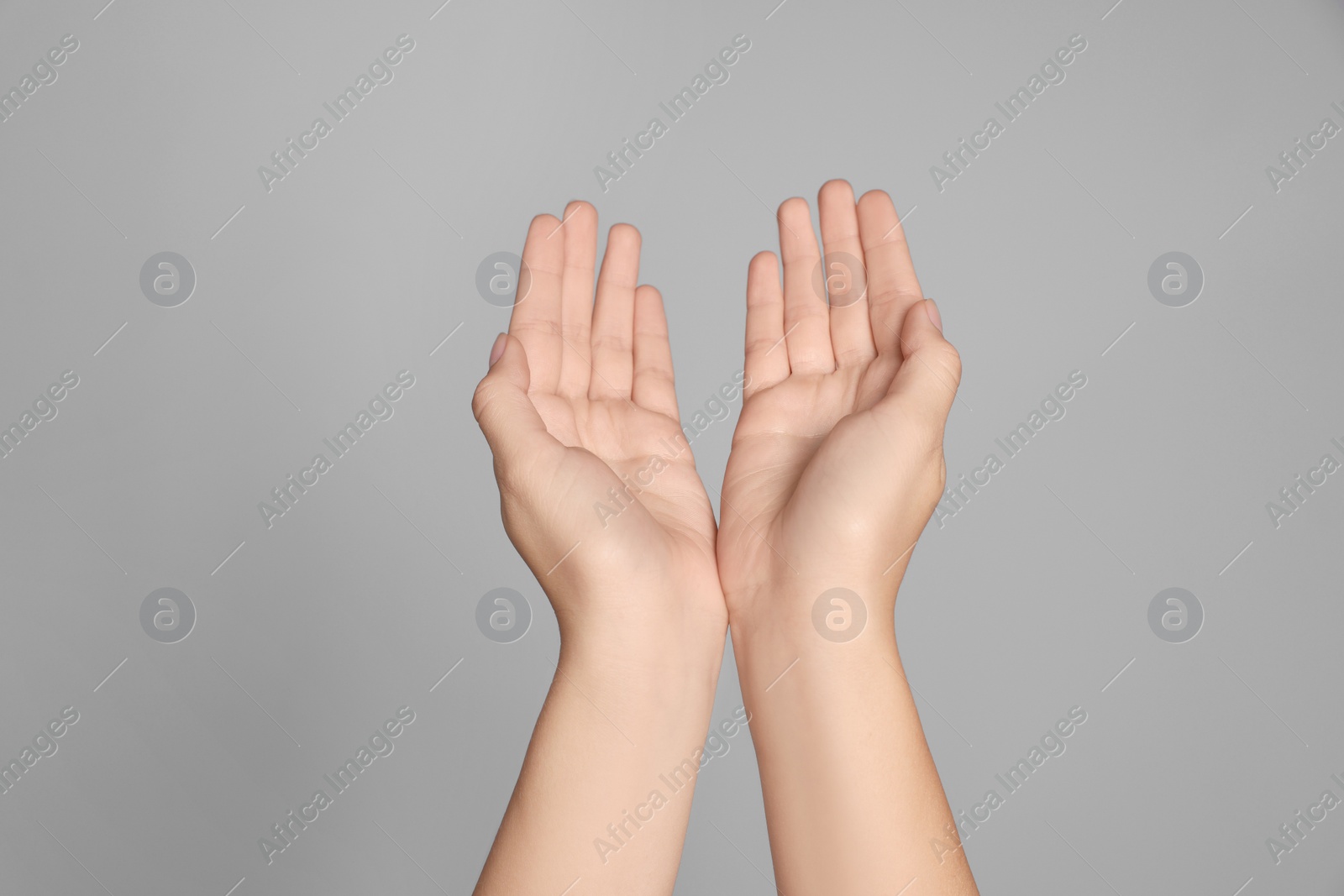 Photo of Woman holding hands against light grey background, closeup