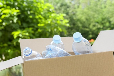 Cardboard box with used plastic bottles outdoors. Recycle concept