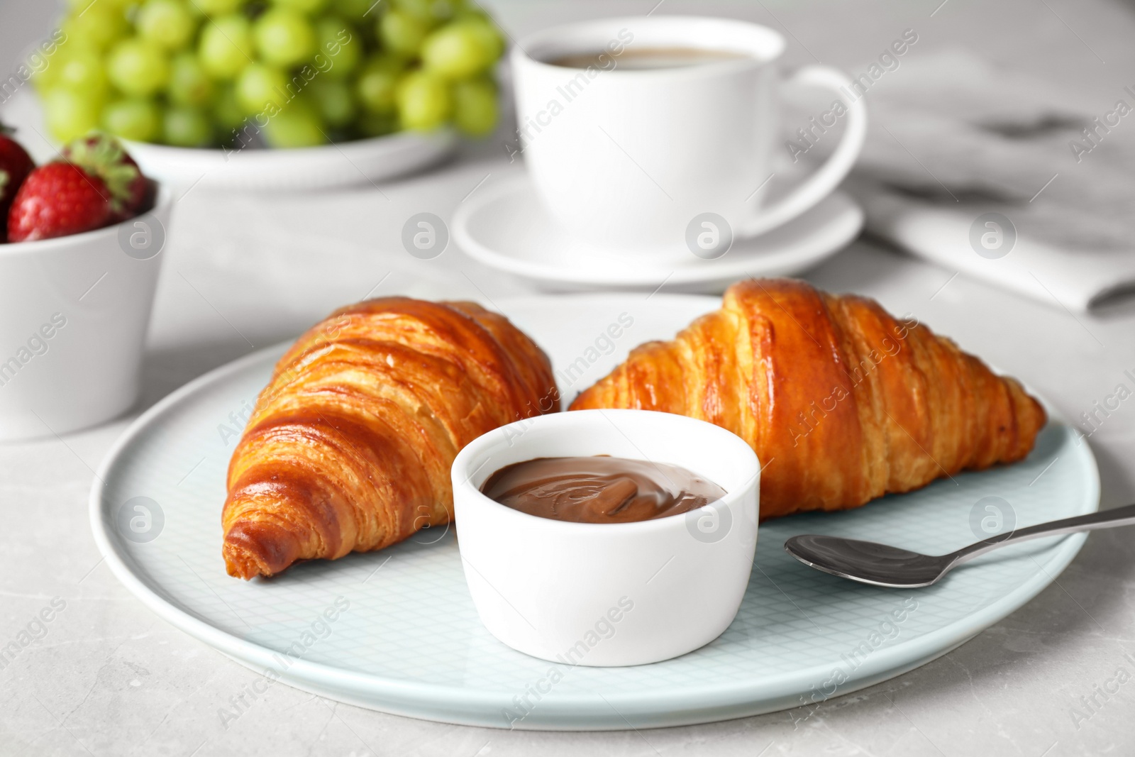 Photo of Delicious breakfast with croissants and chocolate served on light table