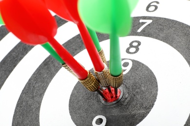 Photo of Dart board with color arrows hitting target, closeup