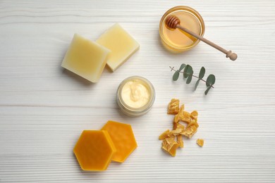 Natural beeswax, cream, honey and eucalyptus on white wooden table, flat lay
