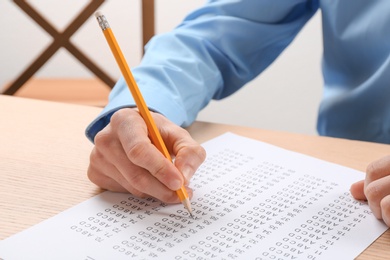 Photo of Student filling answer sheet at table, closeup