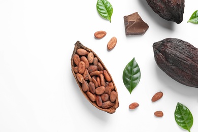 Photo of Cocoa pods with beans and chocolate pieces on white background, top view