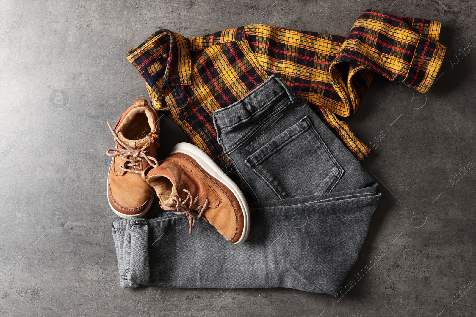 Photo of Stylish child clothes and shoes on grey background, flat lay