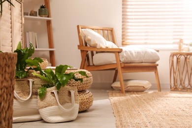 Photo of Stylish living room interior with comfortable wooden armchair and beautiful houseplants