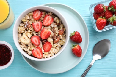 Photo of Flat lay composition with tasty muesli on light blue wooden table. Healthy breakfast
