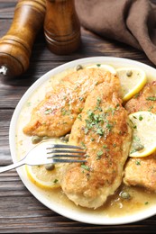 Delicious chicken piccata on wooden table, closeup