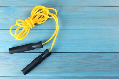 Photo of Skipping rope on light blue wooden table, top view. Space for text