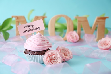 Photo of Festive surprise with tasty treat for Mother's Day on color background