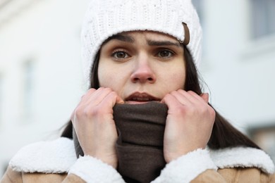 Photo of Sick woman in warm clothes on city street