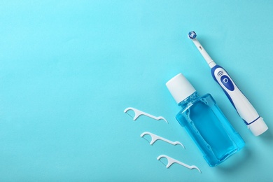 Flat lay composition with electric toothbrush and oral hygiene products on color background