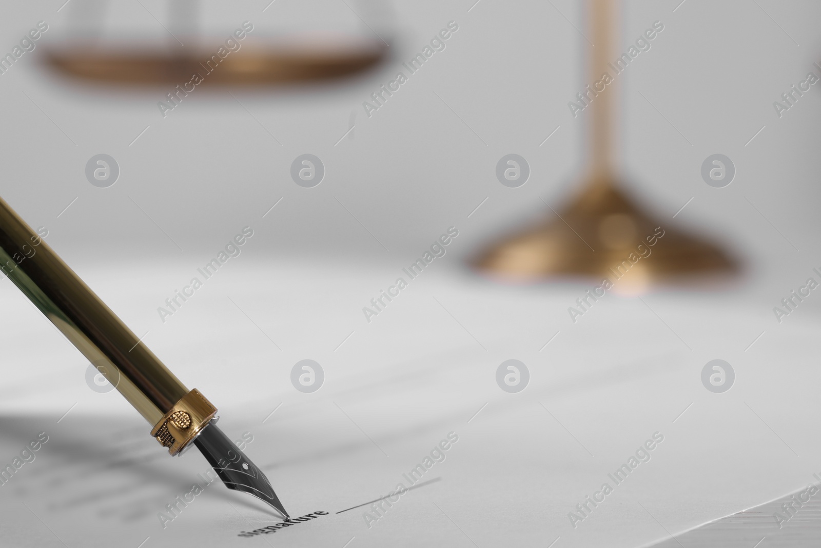 Photo of Signing document with fountain pen at table, closeup and space for text. Notary contract