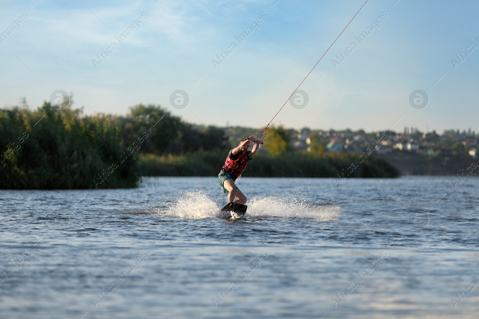 Photo of Man wakeboarding on river. Extreme water sport