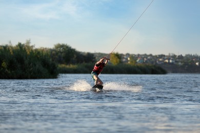 Photo of Man wakeboarding on river. Extreme water sport